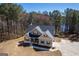 Aerial view of gray two-story home with a welcoming front porch, nestled among lush trees at 624 Bexley Rd, Moreland, GA 30259