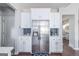 Well-lit kitchen featuring stainless steel refrigerator, white cabinets, and arabesque backsplash at 624 Bexley Rd, Moreland, GA 30259