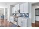 Well-equipped kitchen featuring white cabinets, blue tile backsplash, and stainless-steel appliances at 624 Bexley Rd, Moreland, GA 30259