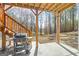 Covered patio with grill and wood staircase overlooks a spacious backyard with mature trees at 624 Bexley Rd, Moreland, GA 30259