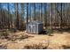 Backyard shed offers additional storage space, complemented by mature trees and natural surroundings at 624 Bexley Rd, Moreland, GA 30259