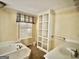 Bathroom featuring a soaking tub, built in shelving, tile floors, and window at 230 White Rd, Fayetteville, GA 30214