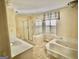 Well-lit bathroom featuring a soaking tub, glass enclosed shower, and a window for natural light at 230 White Rd, Fayetteville, GA 30214