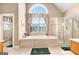 Bright bathroom featuring a soaking tub under a window and a glass-enclosed shower at 1209 Persimmon Way, Mcdonough, GA 30252