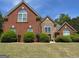 Charming two-story brick home with lush landscaping, arched windows, and a manicured lawn at 1209 Persimmon Way, Mcdonough, GA 30252