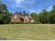 Beautiful brick home with manicured lawn and mature trees for privacy at 1209 Persimmon Way, Mcdonough, GA 30252