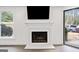Close-up of a living room with a fireplace, windows, and view of the backyard at 1379 Keys Lake Ne Dr, Brookhaven, GA 30319