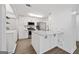 Modern kitchen featuring white cabinets, stainless steel appliances, granite countertops, and two bar stools at kitchen island at 1379 Keys Lake Ne Dr, Brookhaven, GA 30319