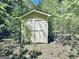 A sturdy shed tucked away in the woods, offering ample storage space in a private location at 114 Rolling Grn, Peachtree City, GA 30269