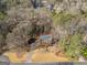 Overhead perspective of a red brick house with a dark roof, showcasing its private lot surrounded by trees at 505 Summer Ter, Woodstock, GA 30189