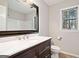 Bathroom with a dark wood vanity with a marble top and a shower with natural light at 505 Summer Ter, Woodstock, GA 30189