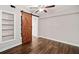 Bedroom features hardwood floors, a sliding barn door, a ceiling fan and built-in shelves at 505 Summer Ter, Woodstock, GA 30189