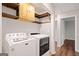 Laundry room featuring modern washer and dryer set, upper cabinets and wood flooring at 505 Summer Ter, Woodstock, GA 30189