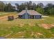 Back exterior of home featuring blue siding, covered patio, trampoline, and large backyard at 296 Beavers Rd, Grantville, GA 30220