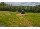Backyard view featuring lush green land and a shed surrounded by tall trees at 296 Beavers Rd, Grantville, GA 30220