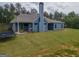Back exterior of home featuring blue siding, covered patio, trampoline and large yard at 296 Beavers Rd, Grantville, GA 30220