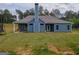 Back exterior of home featuring blue siding, covered patio, and large yard at 296 Beavers Rd, Grantville, GA 30220