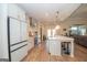 Bright kitchen features an island with seating, white cabinets, stainless appliances, and wood-style flooring at 296 Beavers Rd, Grantville, GA 30220