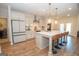 Spacious kitchen with large island, seating, stainless appliances, white cabinets, and adjacent laundry room at 296 Beavers Rd, Grantville, GA 30220