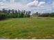 Beautiful, expansive grass covered lot with mature trees in the distance under a partly cloudy sky at 296 Beavers Rd, Grantville, GA 30220