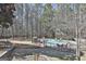 Backyard view of a fenced in pool area with chairs and a patio, all surrounded by natural trees at 190 Postwood Dr, Fayetteville, GA 30215