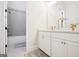 Bathroom with dual vanity, modern fixtures, white cabinets, and shower/tub combo at 114 Village Green Ave, Woodstock, GA 30189