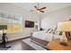 This bedroom features hardwood floors, large windows, a ceiling fan, and a mounted television at 114 Village Green Ave, Woodstock, GA 30189