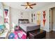 Well-lit bedroom with a ceiling fan, a baseball-themed rug, and pennants on the wall at 114 Village Green Ave, Woodstock, GA 30189