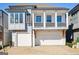 Beautiful new home features a two-car garage, covered front porch, and gray siding at 114 Village Green Ave, Woodstock, GA 30189