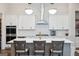 Bright kitchen with an island featuring barstool seating, quartz countertops, and white cabinets at 114 Village Green Ave, Woodstock, GA 30189