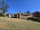 Rear exterior view showcasing a brick house with a deck and access to the backyard at 5447 Ahyoka Dr, Morrow, GA 30260