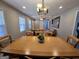 Dining room showcases natural wood table and chairs, views to the living room, and modern chandelier at 5447 Ahyoka Dr, Morrow, GA 30260