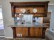 Kitchen featuring a breakfast bar with granite countertop, wood cabinetry, and decorative display shelves at 5447 Ahyoka Dr, Morrow, GA 30260