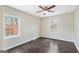 Bright bedroom with two windows, dark wood floors and ceiling fan creating a comfortable and inviting atmosphere at 2589B Se Fieldstone View Ln, Conyers, GA 30013