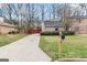 Traditional home featuring a spacious driveway, mature trees, and a welcoming yard at 2589B Se Fieldstone View Ln, Conyers, GA 30013