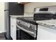 Close-up of a stainless steel oven in kitchen featuring granite countertops and modern white cabinets at 2589B Se Fieldstone View Ln, Conyers, GA 30013