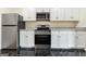 Well-equipped kitchen boasts stainless steel appliances, granite countertops, and white cabinets with modern fixtures at 2589B Se Fieldstone View Ln, Conyers, GA 30013