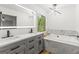 Modern bathroom boasts double vanity, elegant lighting, and separate tub with marble surround at 125 Marilyn Ct, Fayetteville, GA 30214