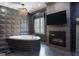 Elegant bathroom with a soaking tub, modern fireplace, geometric wall tiles, and stylish chandelier at 4100 Oak Hill Rd, Douglasville, GA 30135