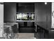 Close-up of kitchen with built-in ovens, black cabinets and marble countertops with tiled floor at 4100 Oak Hill Rd, Douglasville, GA 30135