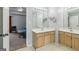 Bathroom featuring dual vanities, light wood cabinets, mirrors, and access to bedroom at 848 Gateshead Ct, Lawrenceville, GA 30043