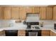 Kitchen features white countertops, wooden cabinets, and a black oven range with subway tile backsplash at 848 Gateshead Ct, Lawrenceville, GA 30043