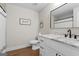 Well-lit bathroom featuring a framed mirror, granite countertops and wood-look floors at 1017 Riverstone Dr, Social Circle, GA 30025