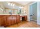 A bathroom with dual sinks, wooden cabinets, and hardwood floors at 6365 Mountain View Trl, Cumming, GA 30041