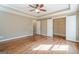 A large bedroom with wood floors, neutral walls, and a ceiling fan at 6365 Mountain View Trl, Cumming, GA 30041