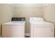 Convenient laundry room equipped with a washer, dryer, and shelving at 6365 Mountain View Trl, Cumming, GA 30041