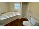 Bright bathroom features a jetted tub, separate shower, and wood-look flooring at 9184 Thrash Sw St, Covington, GA 30014
