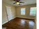 Bright bedroom featuring hardwood floors and natural light from two windows at 9184 Thrash Sw St, Covington, GA 30014