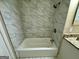 Bathroom shower featuring white marbled tile, shower head and updated fixtures at 4352 Glenwood Pkwy, Decatur, GA 30032