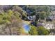 Aerial view showcasing a tennis court and the surrounding wooded landscape of the property at 3099 Balearic Se Dr, Marietta, GA 30067